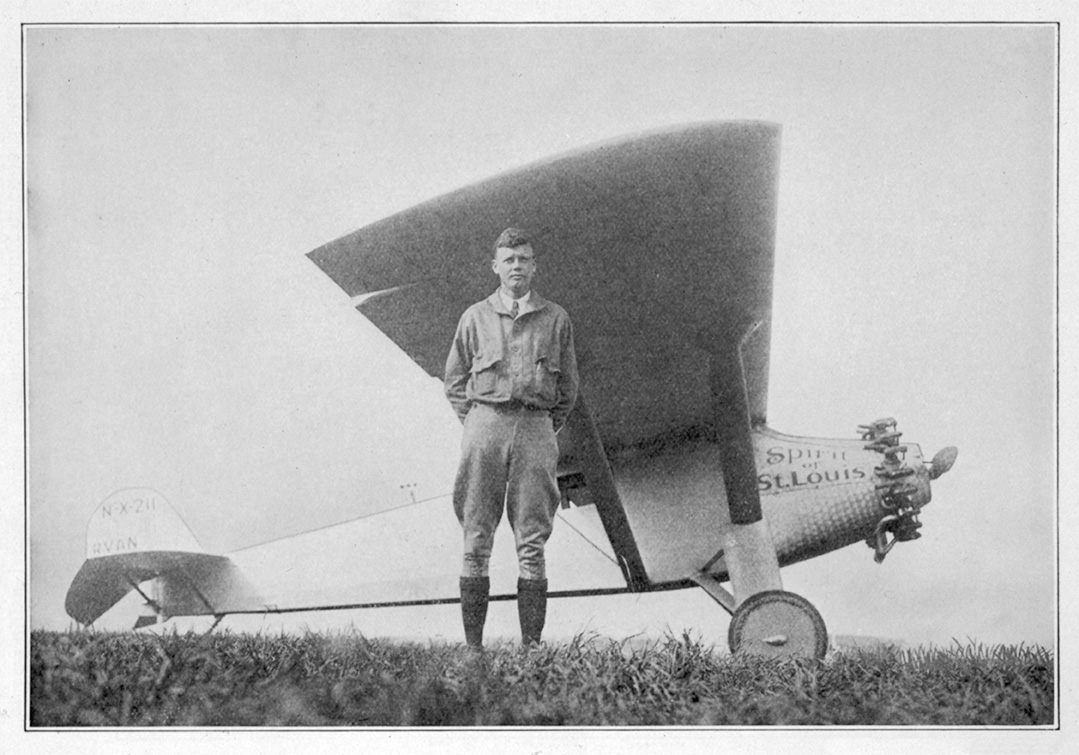 Charles Lindbergh standing next to Spirit of St. Louis airplane